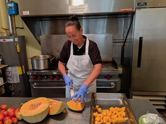 OTRS employee helps at Dorothy Day Soup Kitchen with cutting pumpkins