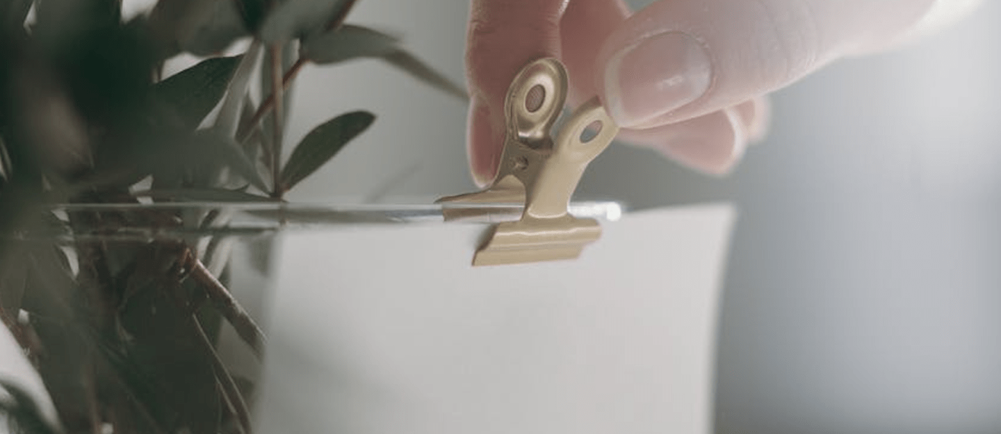 Hand clipping a ticket to a vase
