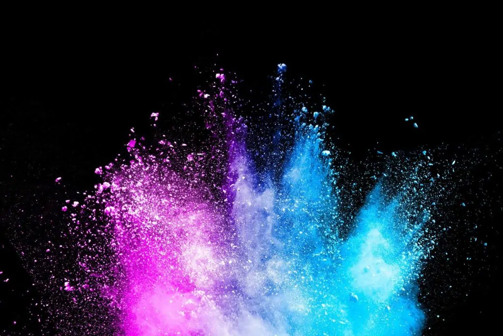 Colorful explosion of pink purple and light blue liquid on a black background