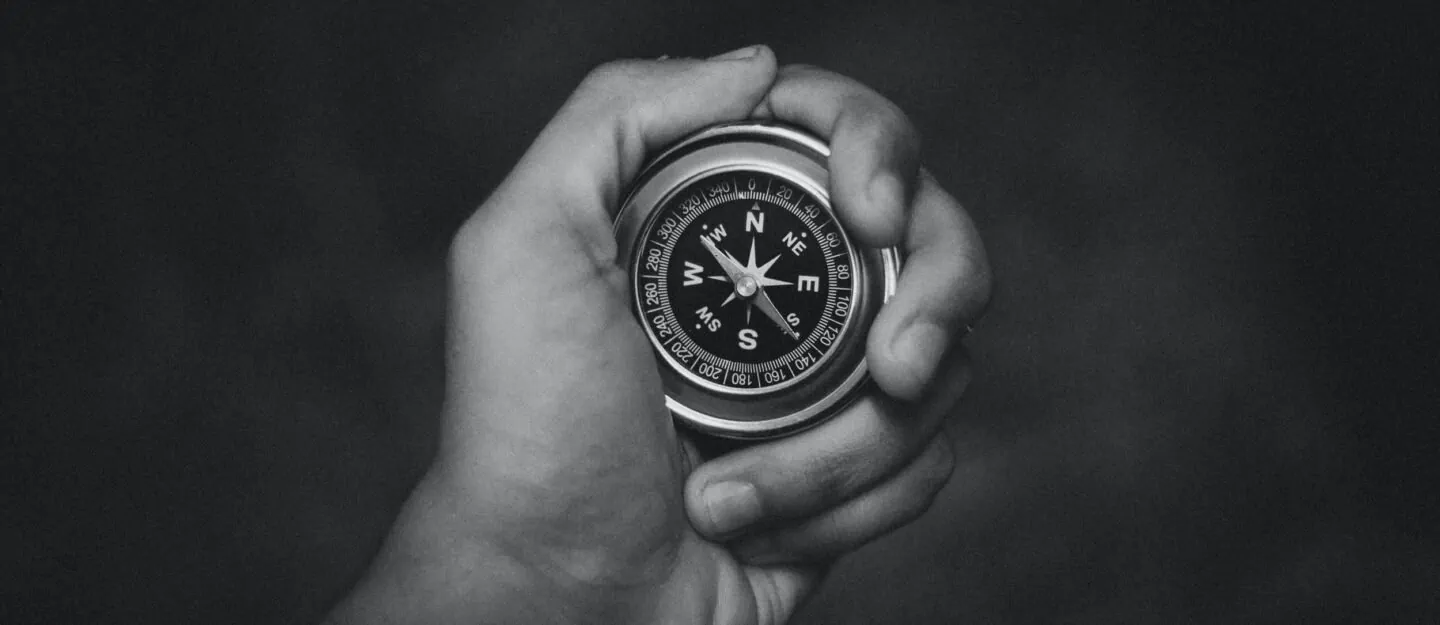 hand holds a compass