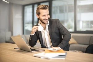 Man smiling with coffee at work to represent what GDPR means to businesses